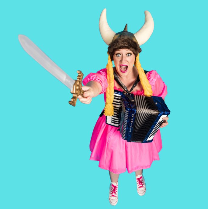 Madame Chandelier's Opera Party for Kids. A cut out of a women in a bright pink dress holding a plastic sword wearing a viking horn helmet against a bright blue background