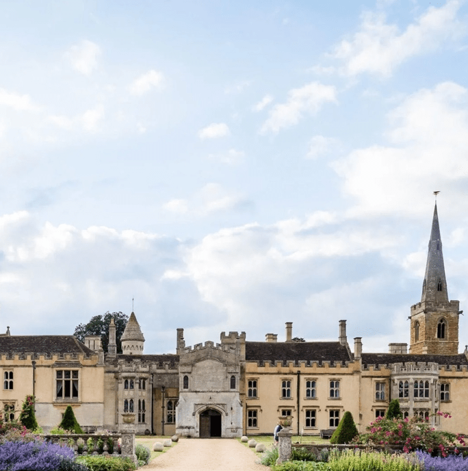 country house podcast - Nevil Holt. A large manor house agains a blue sky