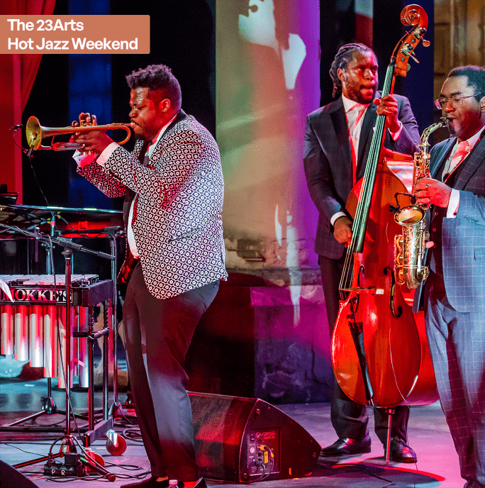 Musical Maestros and the Birth of Swing. A collection of jazz musicians playing a mixture of instruments live on stage with colourful lighting